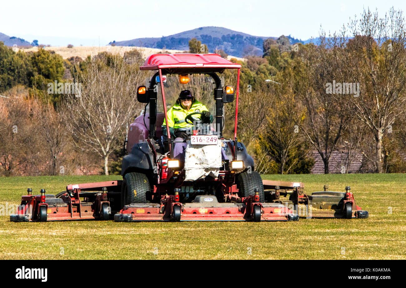 Operator mowing sports field Stock Photo