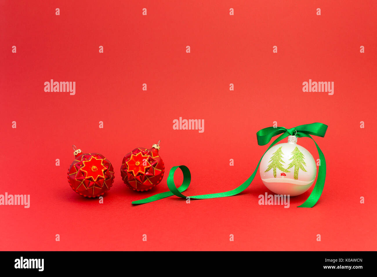 Beautiful white and red christmas balls with green silky ribbon on red ...