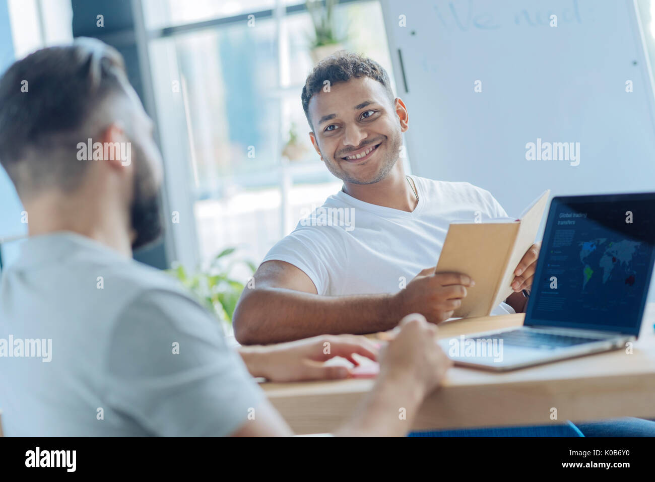 Handsome cheerful man looking at his colleague Stock Photo