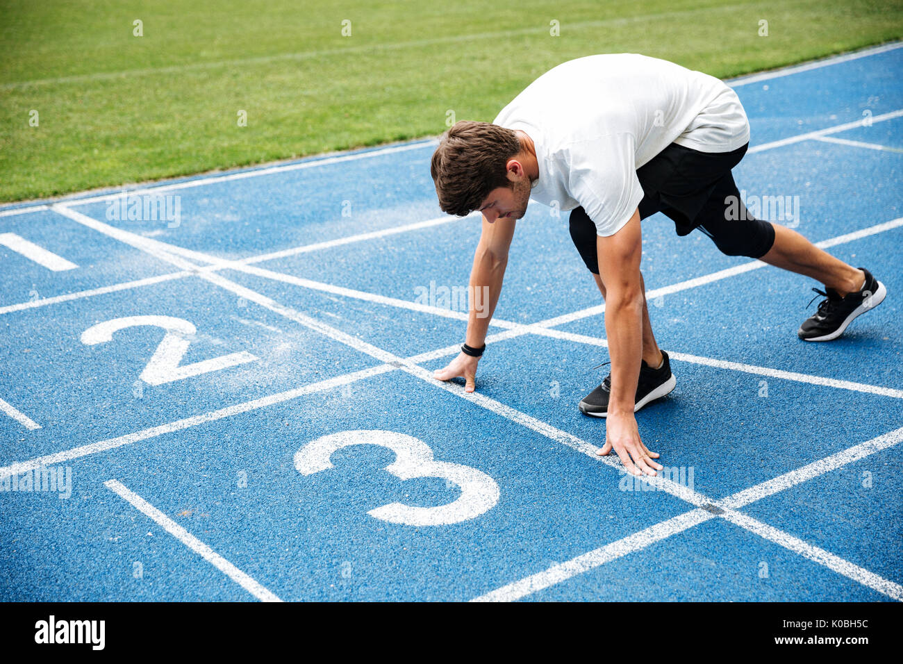 Male Athlete On Starting Position At Athletics Running Track Stock Photo -  Download Image Now - iStock