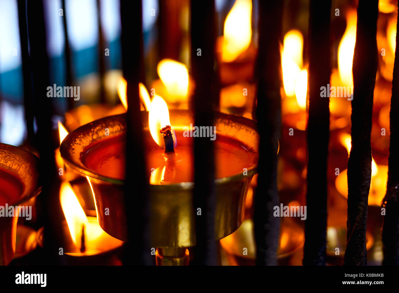close up on big oil lamp with blurred bokeh of other lighing lamps on background which are lighted inside the cage Stock Photo