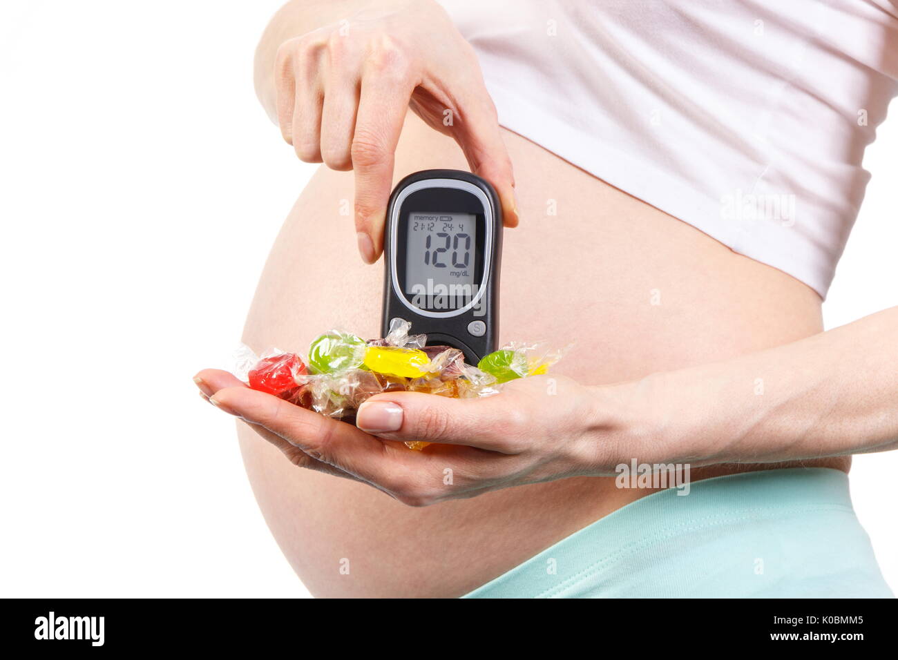 Pregnant woman holding colorful candies and with result of