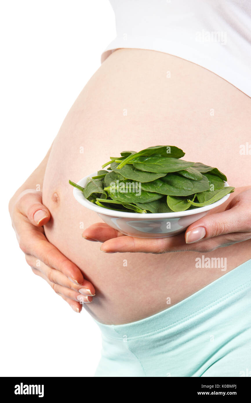 Pregnant woman with portion of fresh green spinach, concept of healthy