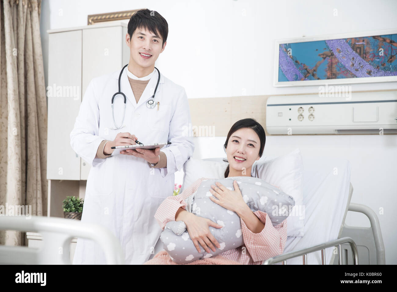 Smiling doctor and mother holding her newborn baby at hospital Stock ...