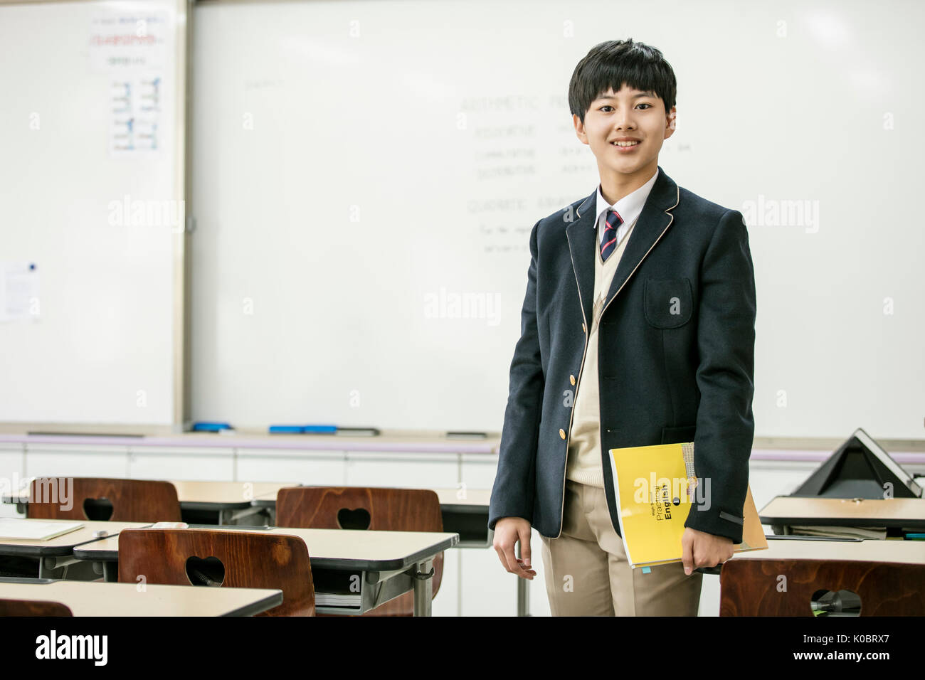 Smiling school boy standing in classroom Stock Photo