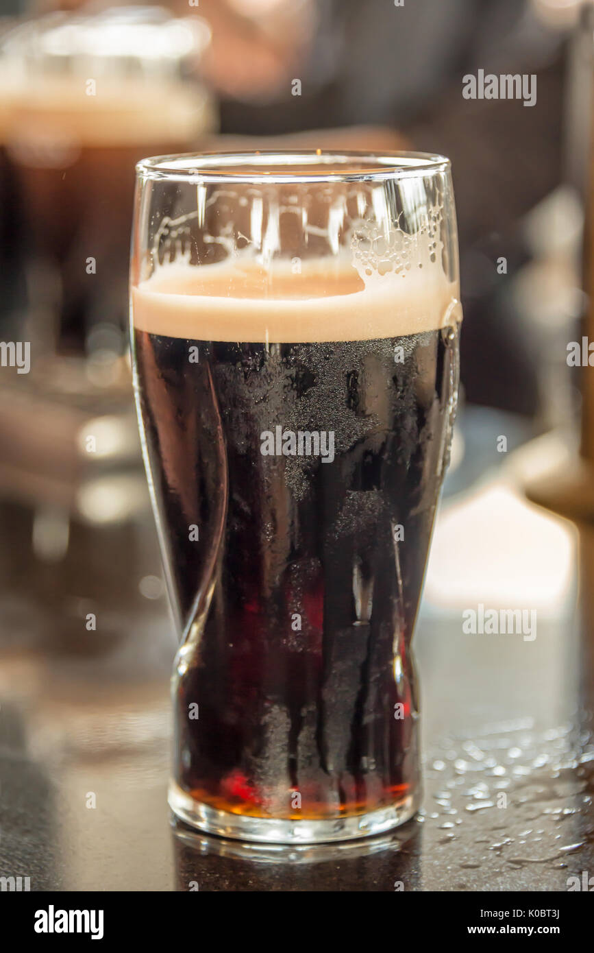 Close up of a glass of stout beer on a bar counter Stock Photo