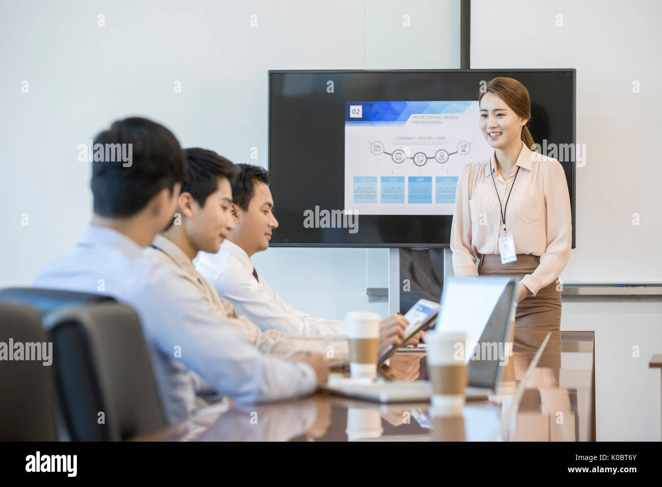 Smiling businesswoman having a presentation in front of her coworkers Stock Photo