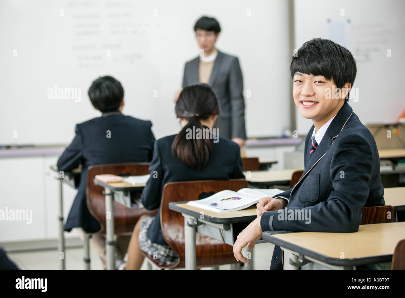 Portrait of smiling school boy with his classmates and teacher in classroom Stock Photo