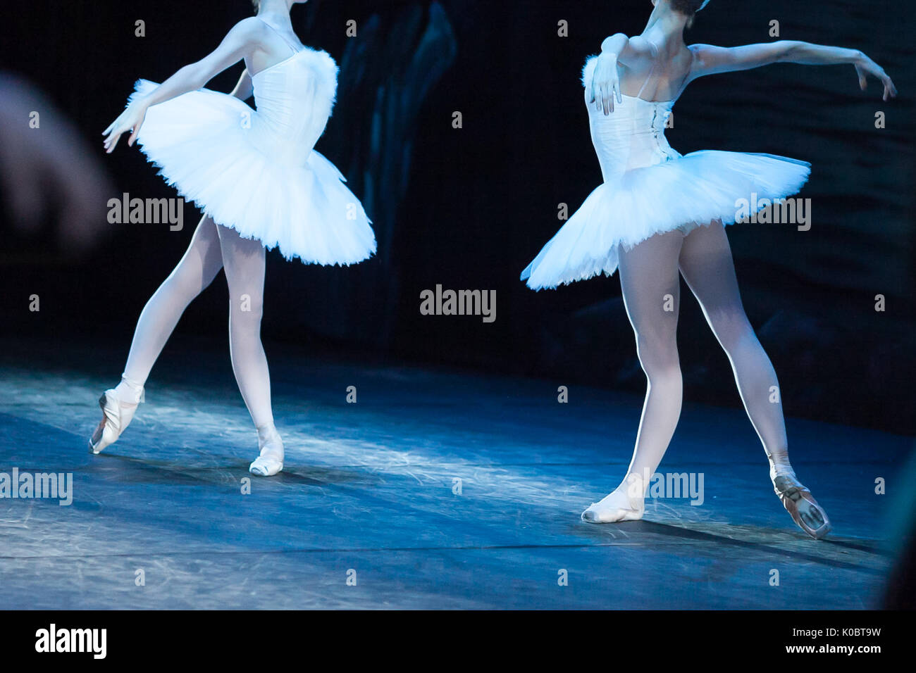 choreography, art, ballet concept. impeccable bodies of two female ballet dancers are shinning in bright light of projectors, they raising their hands like beautiful and majestic swans Stock Photo - Alamy