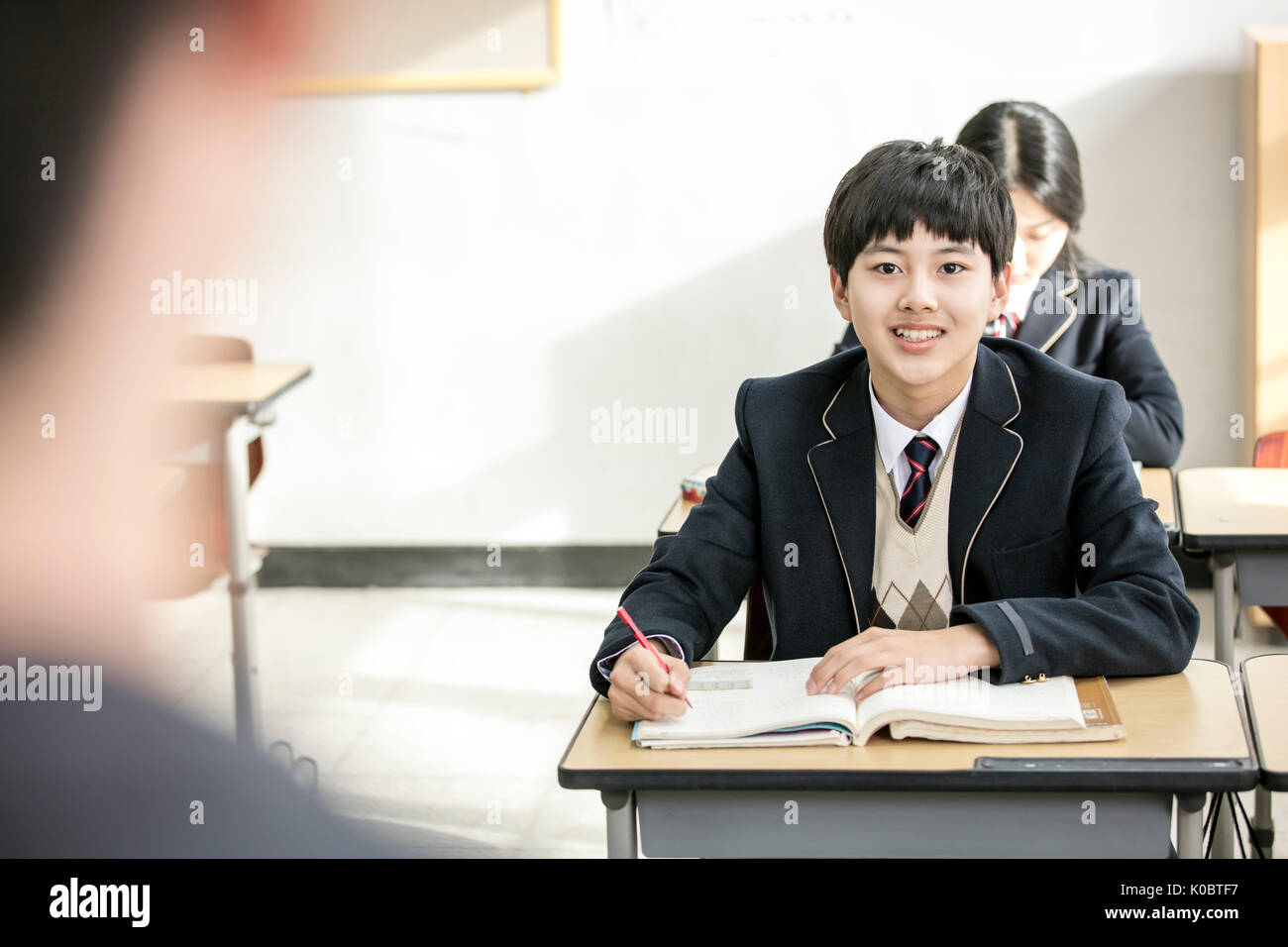 Po Portraitof smiling school boy looking at his teacher in class Stock Photo