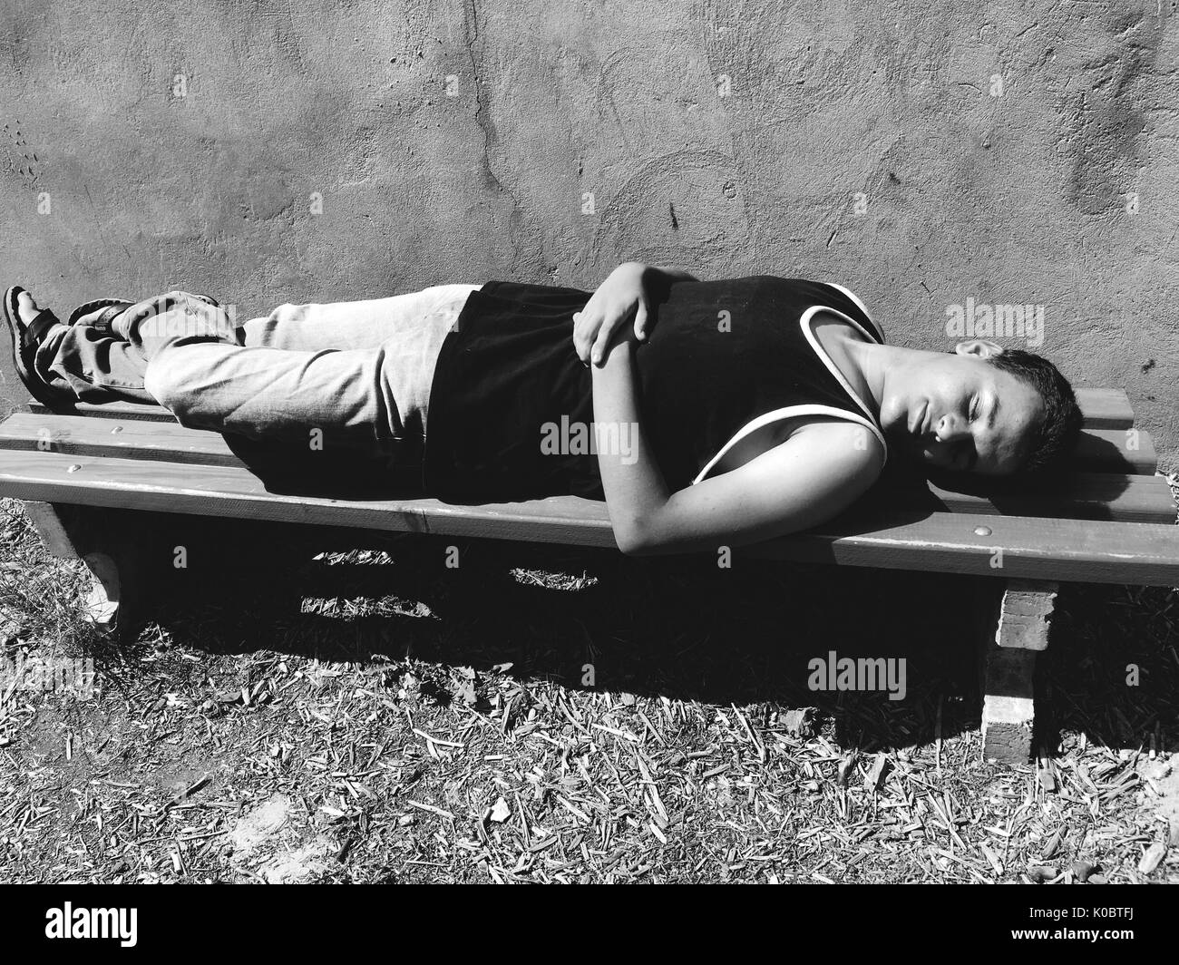 Boy sleeping on park bench hi-res stock photography and images - Alamy