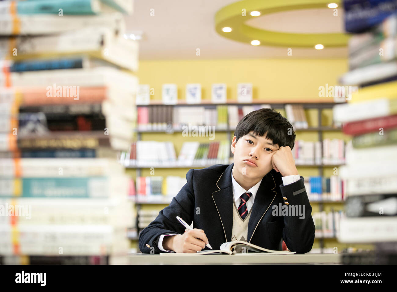 Portrait of school boy bored in library Stock Photo