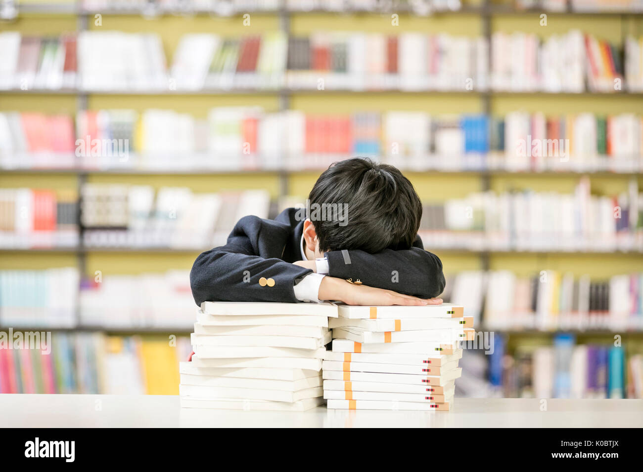 Portrait of school boy tired in library Stock Photo
