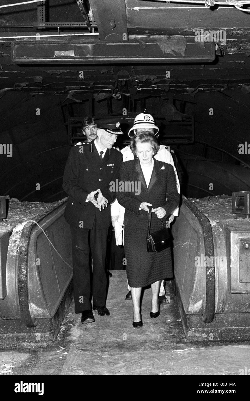 The Prime Minister Margaret Thatcher, escorted by Deputy Chief Fire Officer Mike Doherty, tours the fire-damaged ticket hall of King's Cross Underground Station. Stock Photo