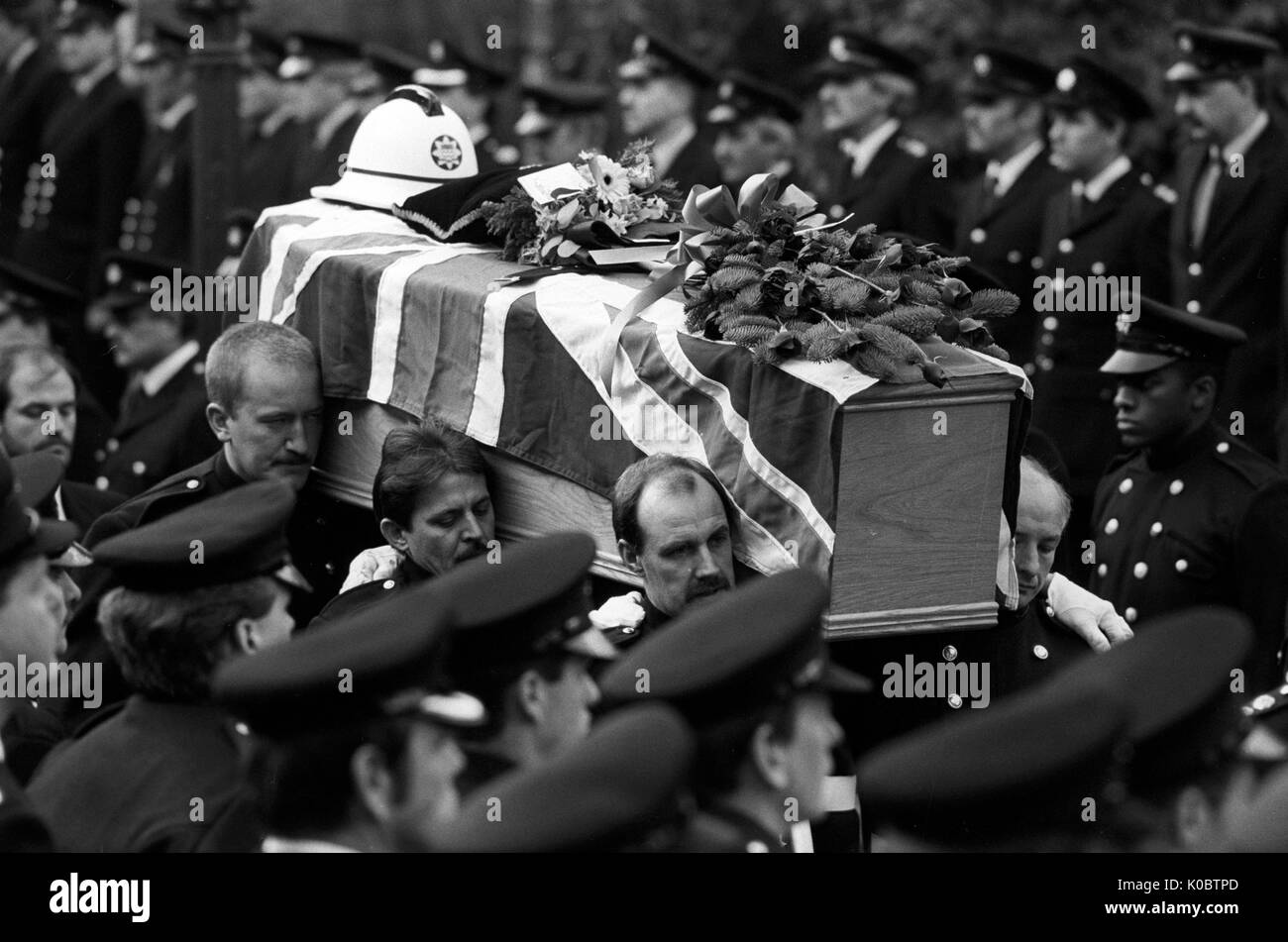 Station Officer Colin Townsley's coffin, bearing his helmet, is carried by his colleagues from Red Watch into St Paul's Church, Covent Garden. Front centre is pallbearer Sub Officer Vernon Trefry, who was injured in the King's Cross fire. Stock Photo