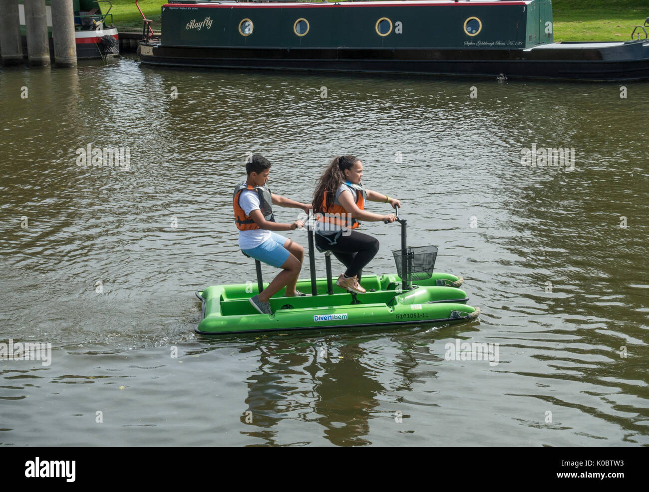 Youths pedalling a water bike on the river Great Ouse Stock Photo