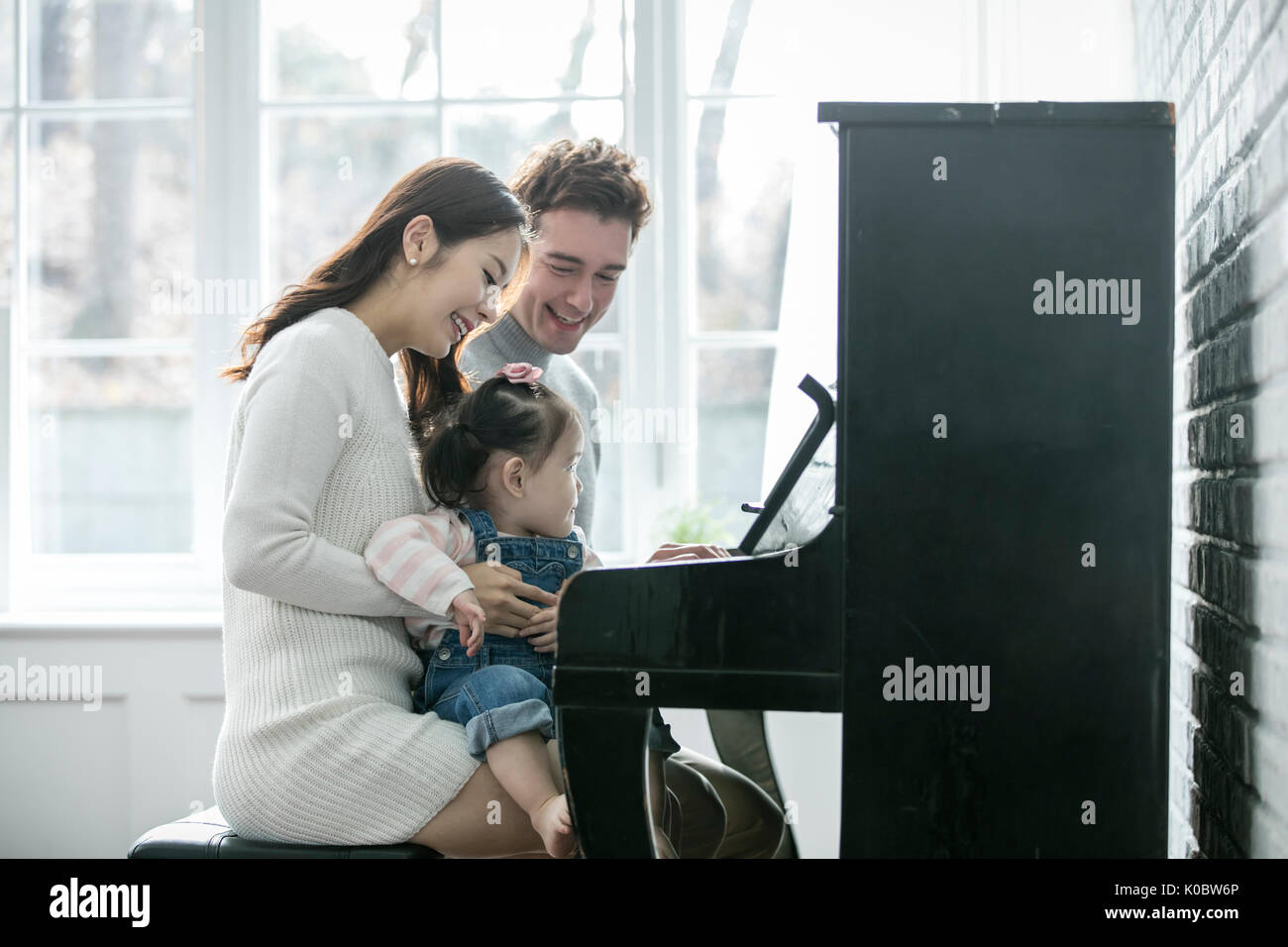 Harmonious multicultural family playing a piano Stock Photo