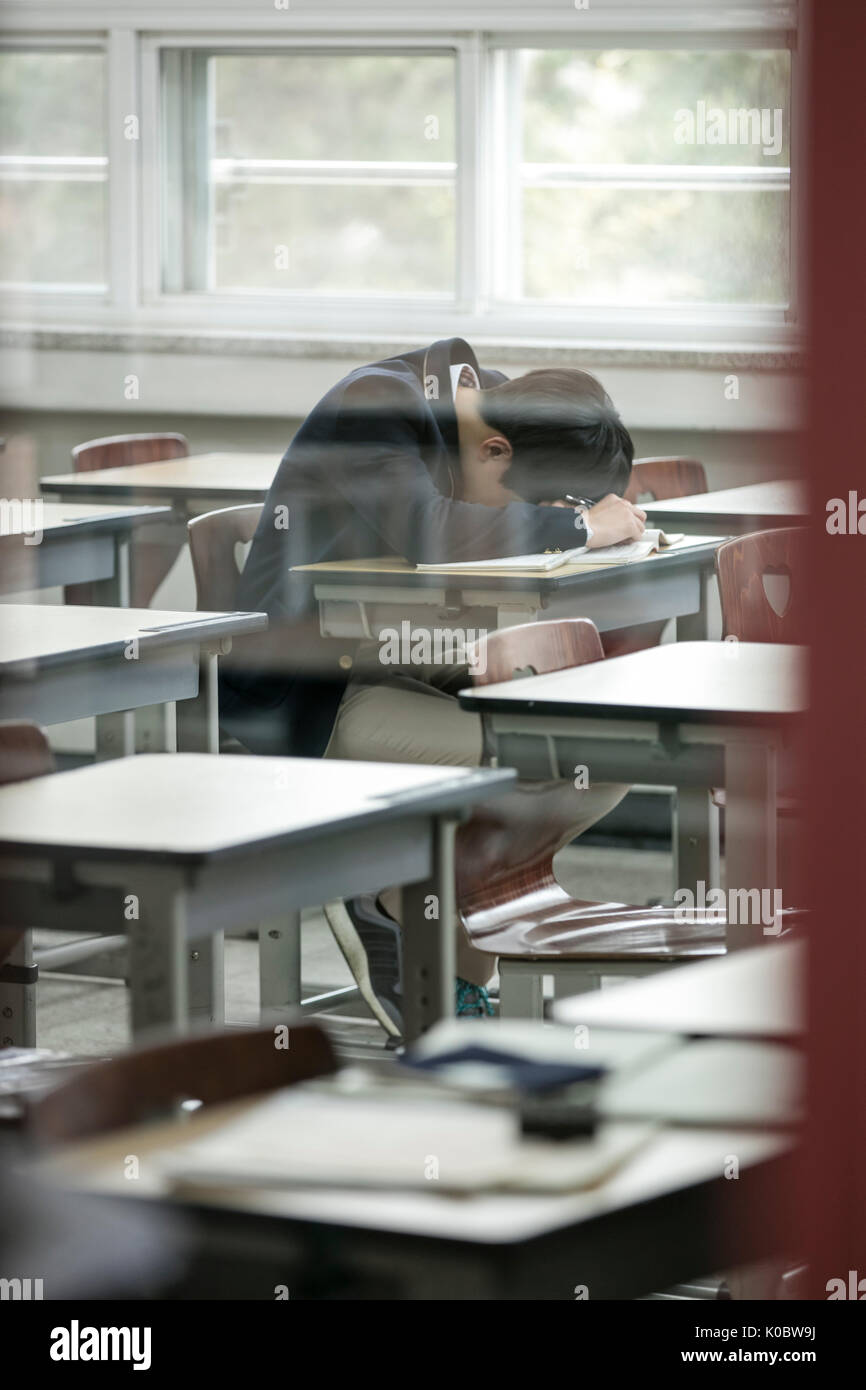 Side view portrait of Korean school boy gloomy in classroom Stock Photo