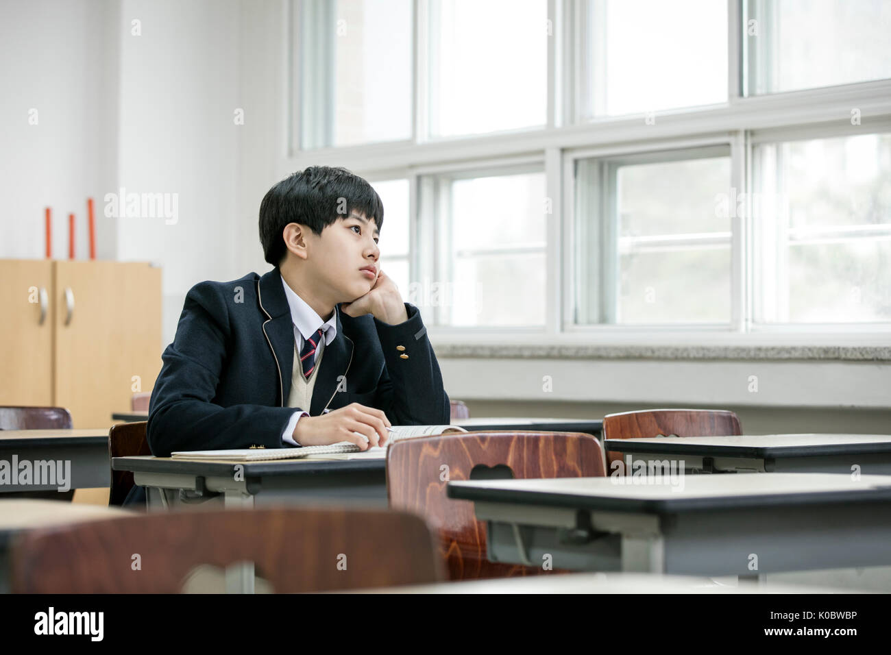 Side view portrait of school boy solitary in classroom Stock Photo