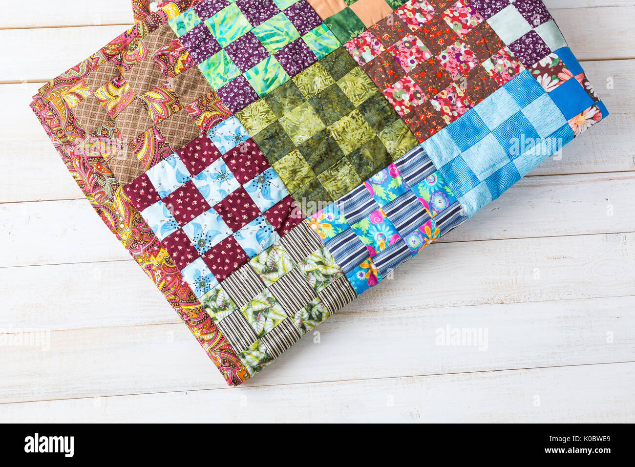 comfort, accessories, art, creation, style concept - original handiwork in asian traditions made of little textile squares in red, green and blue shades with such prints as flowers, leaves and strips Stock Photo