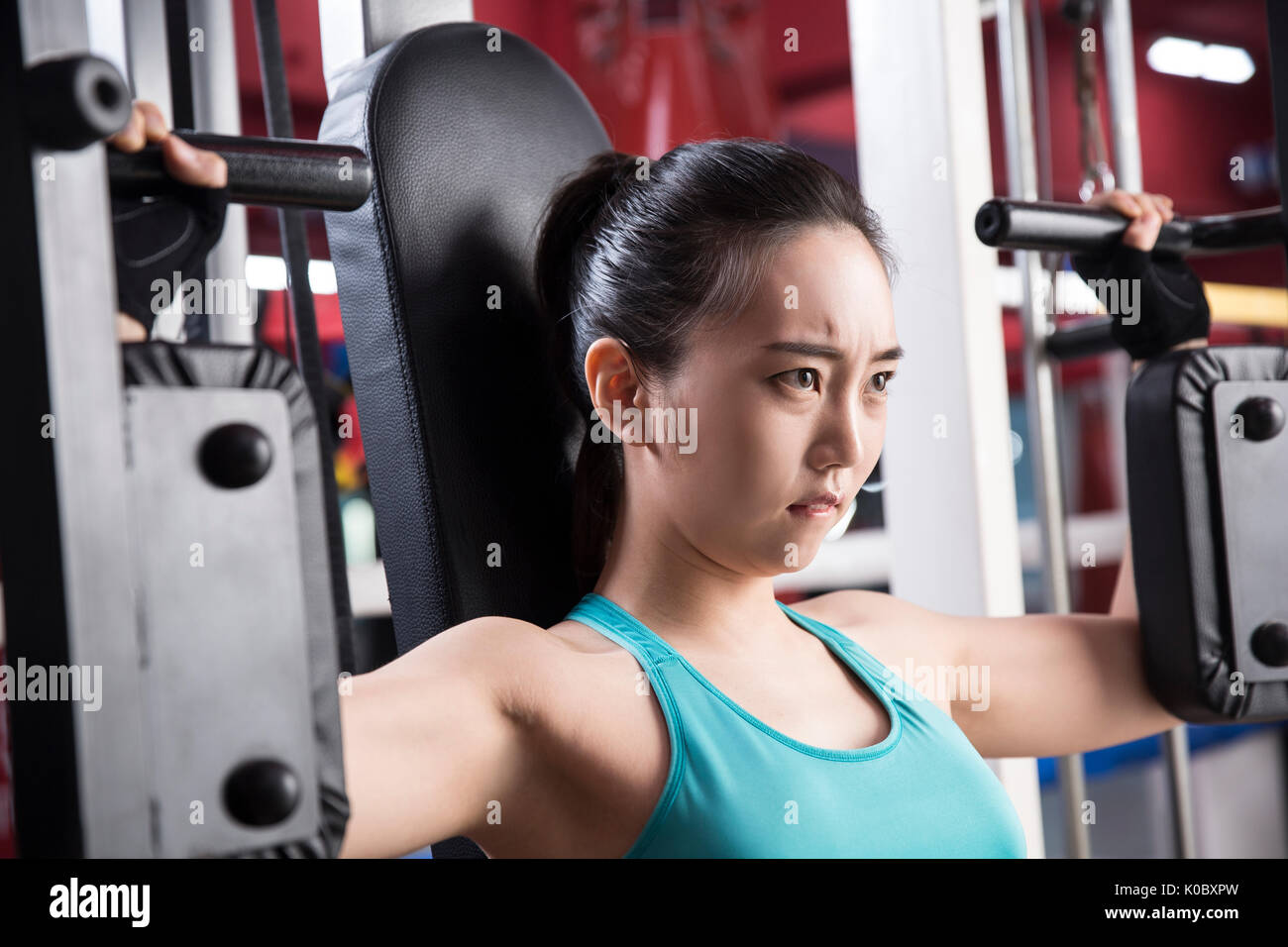 Side view portrait of young woman exercising at health club Stock Photo