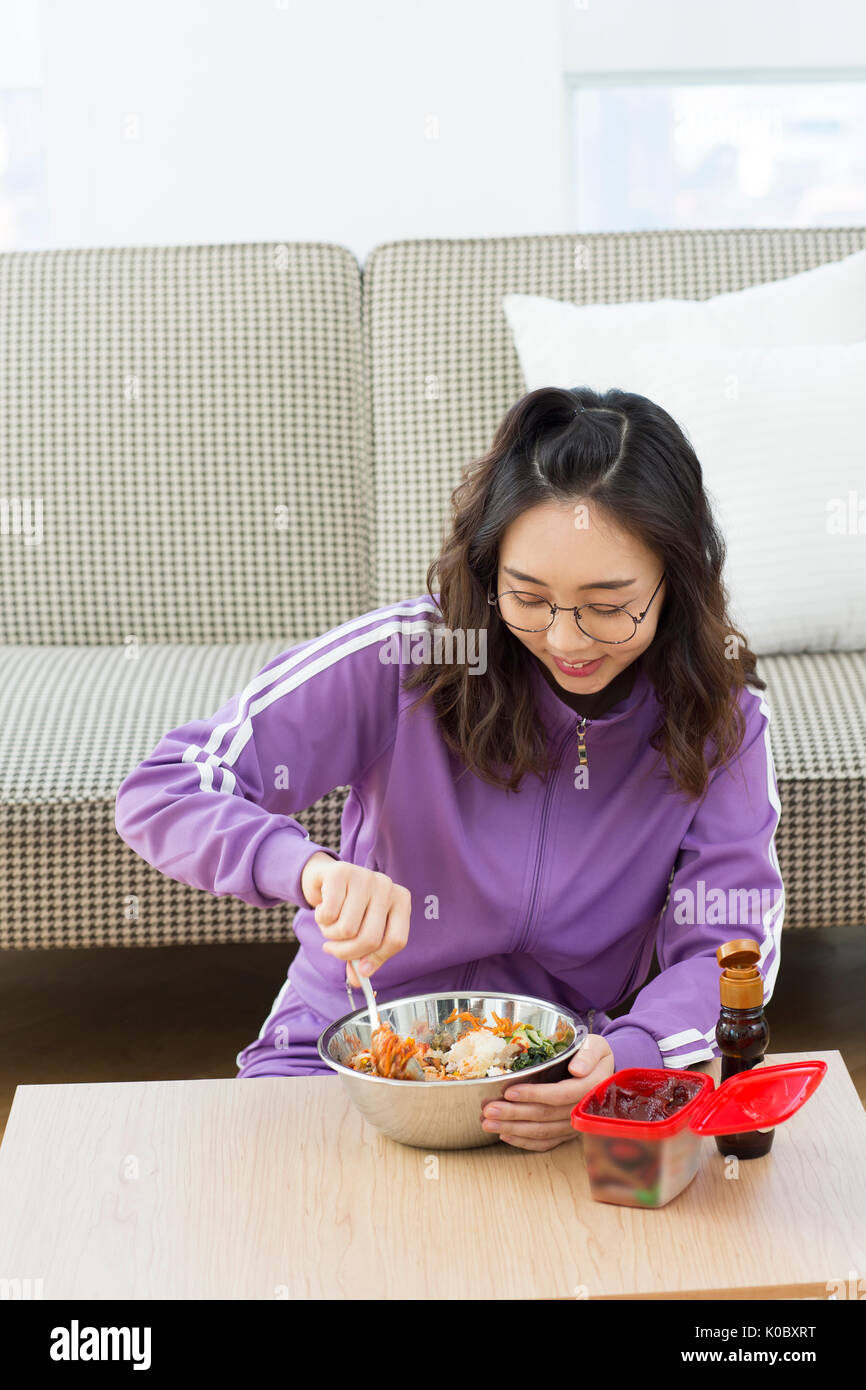 Young NEET woman eating bibimbap Stock Photo