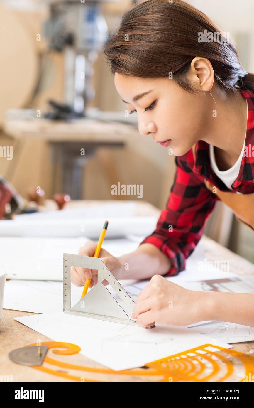 Side view portrait of young female furniture designer working Stock Photo
