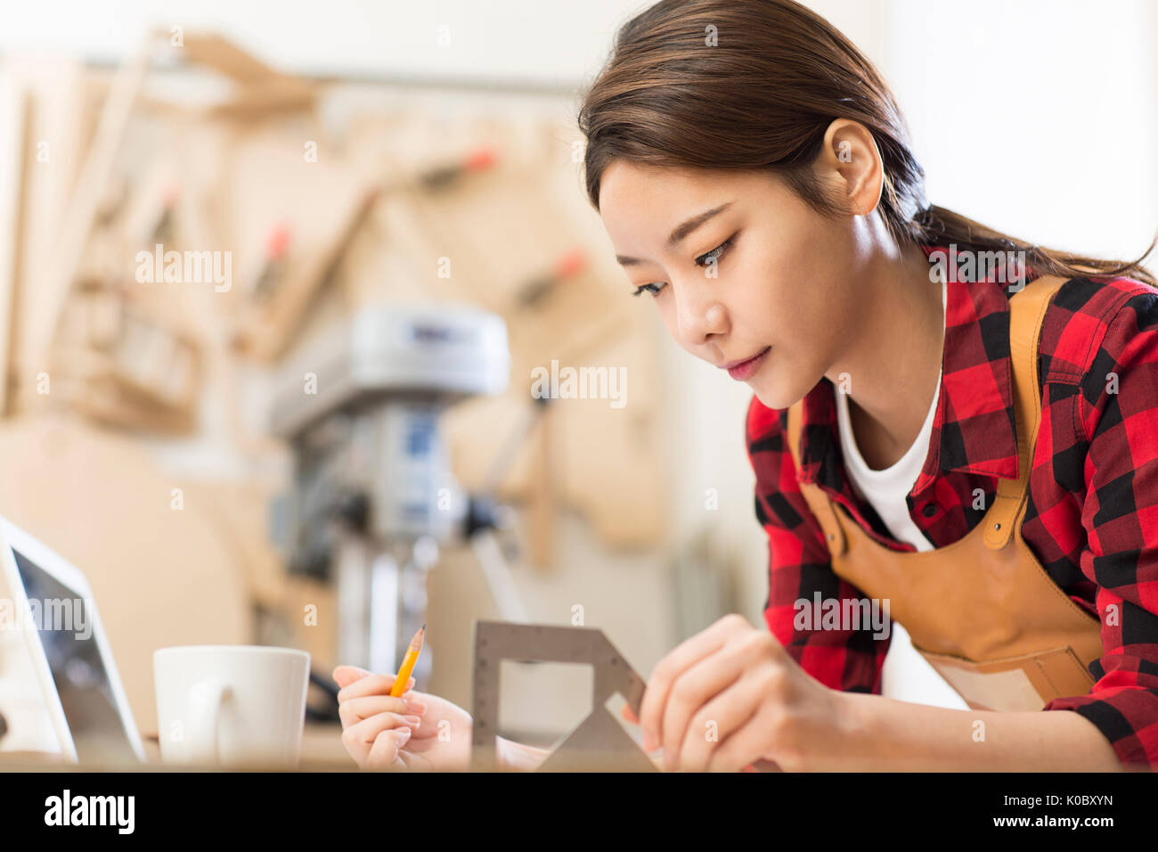 Side view portrait of young female furniture designer concentrating on her work Stock Photo