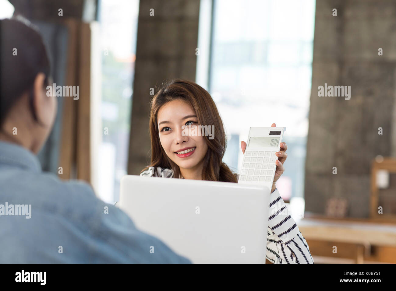 Portrait of young smiling female furniture expert dealing with customer Stock Photo