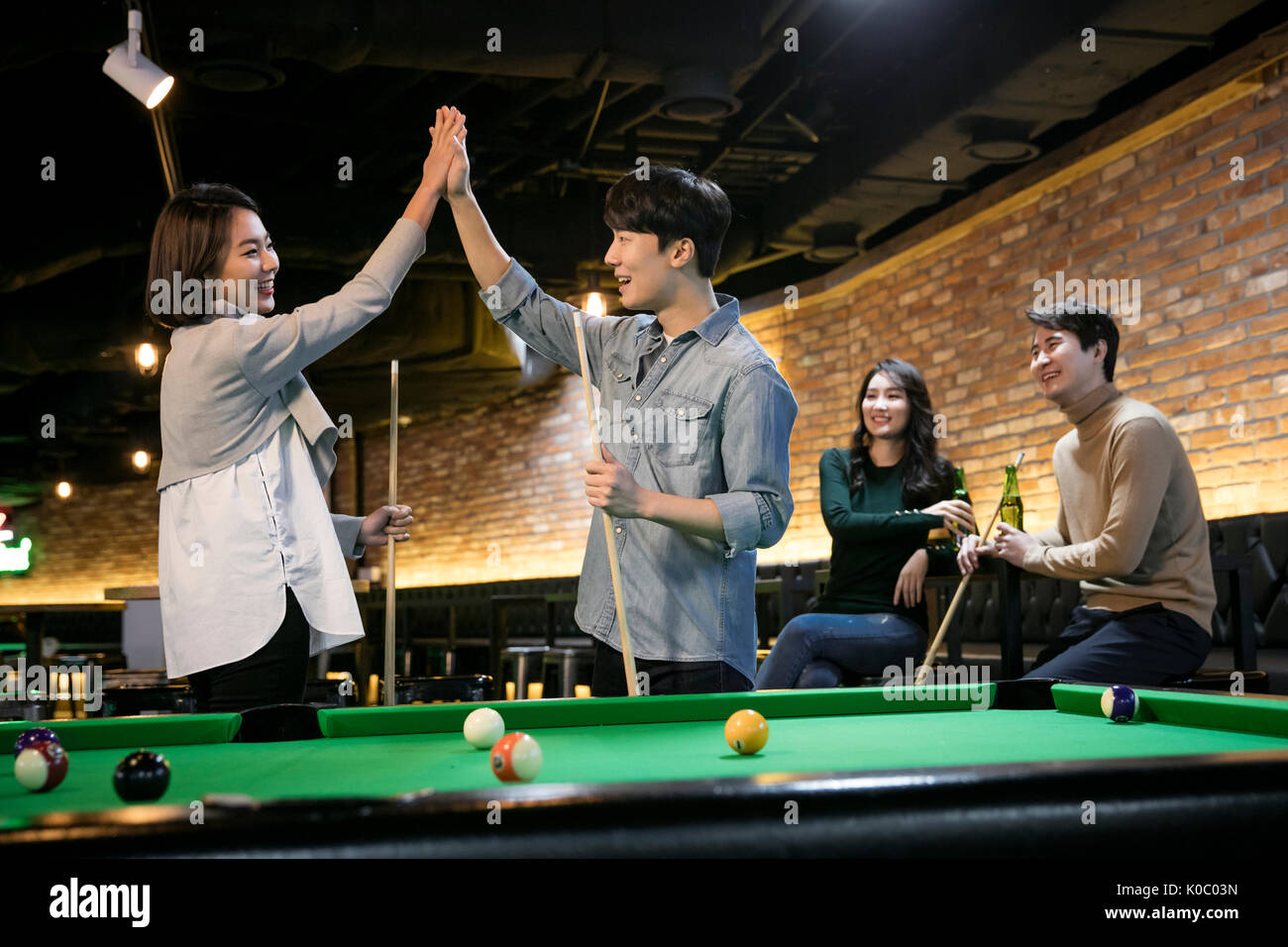 Smiling coworkers enjoying billiard game Stock Photo