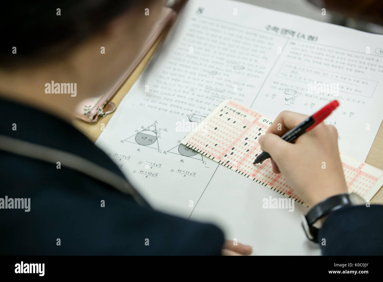 Back portrait of school girl taking exam Stock Photo