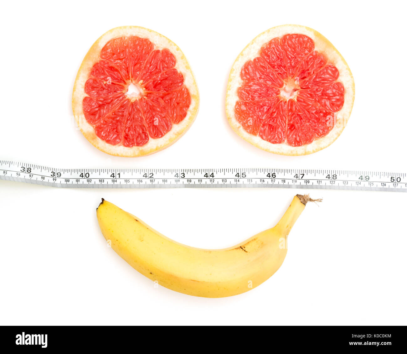 Smiling face made from grapefruit, banana and tape measure,  on white background,Diet concept Stock Photo