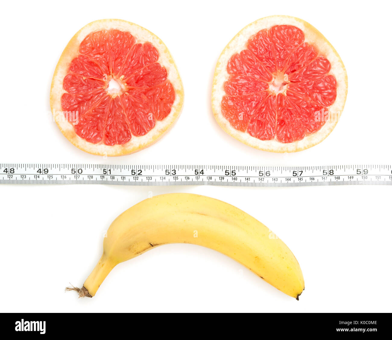 Sad face made from grapefruit, banana and tape measure,  on white background,Diet concept Stock Photo
