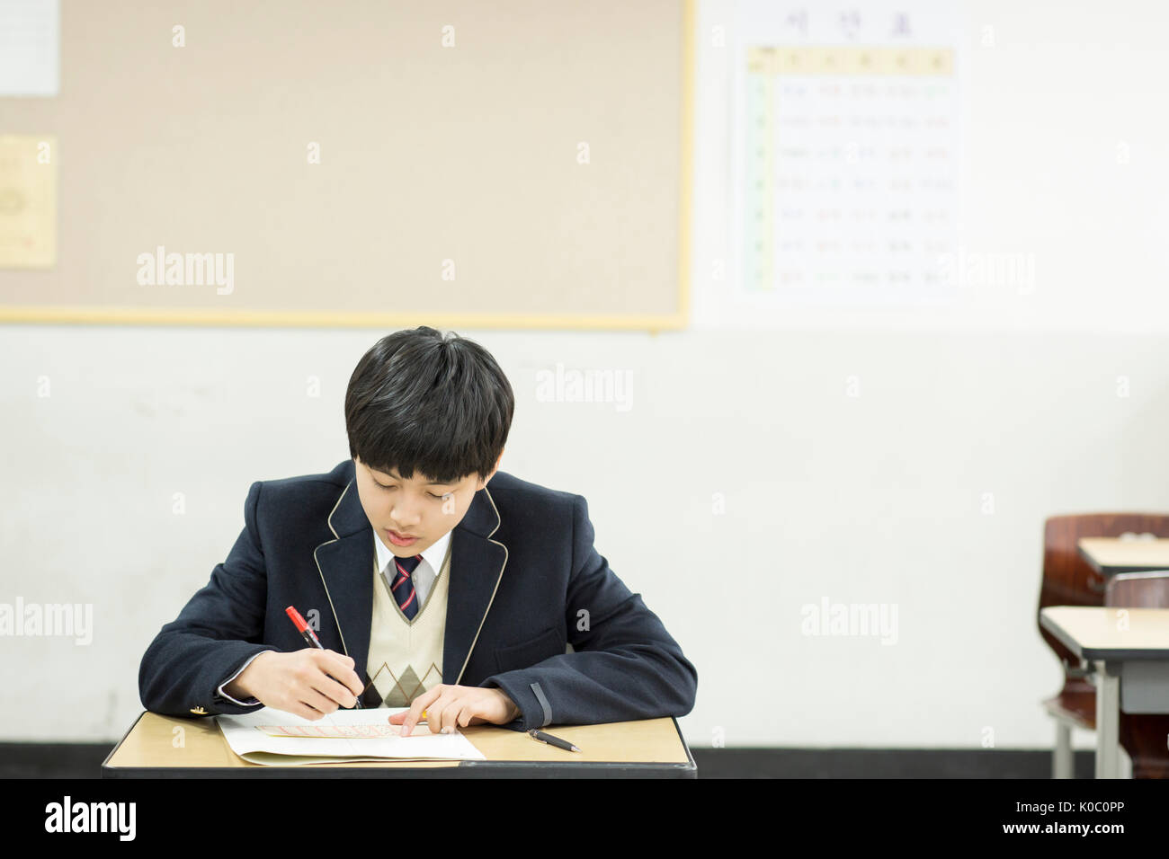 Portrait of school boy taking exam Stock Photo
