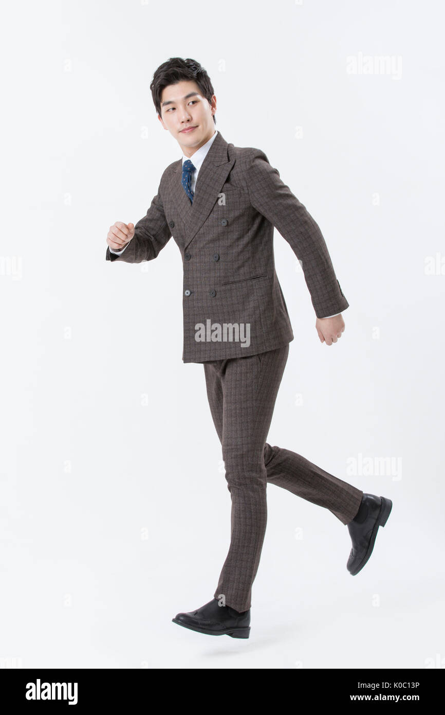 Young smiling businessman in suit running Stock Photo