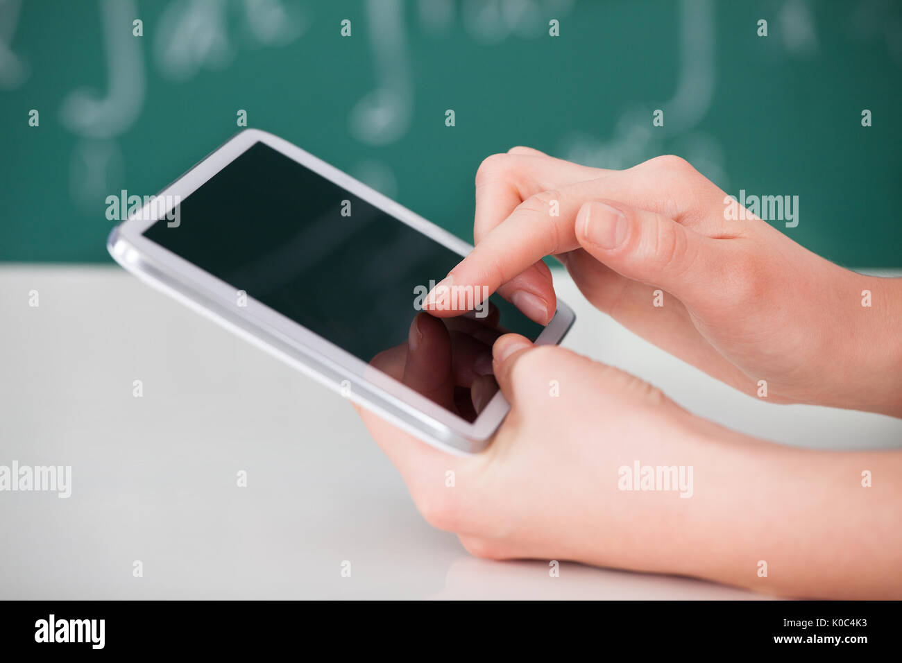 Cropped image of young woman using digital tablet in classroom Stock Photo