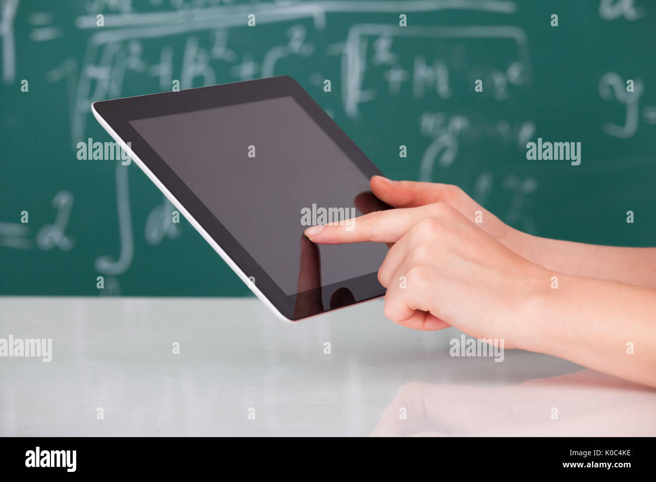 Cropped image of young woman using digital tablet in classroom Stock Photo