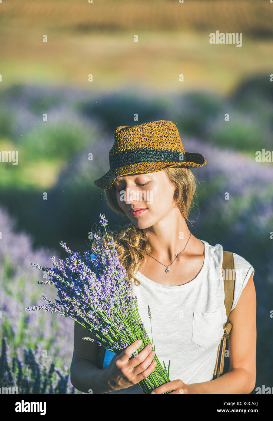 Girl wearing straw hat with a bouquet of lavender flowers Stock Photo ...