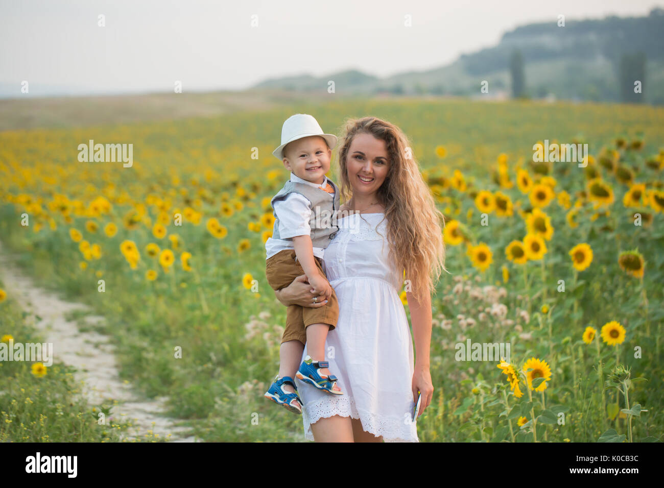 Mother with baby son in sunflower field Stock Photo - Alamy