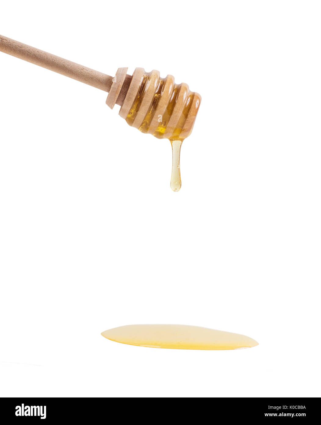 Honey is dripping from the wooden spoon. Stock Photo