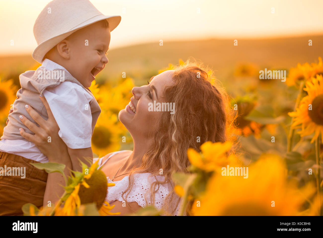 Mother with baby son in sunflower field Stock Photo - Alamy