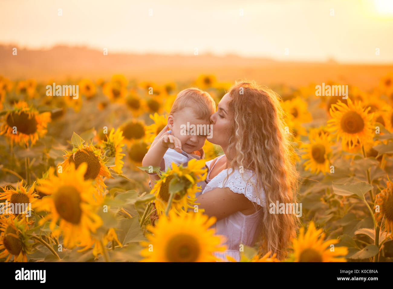 Mother with baby son in sunflower field Stock Photo - Alamy