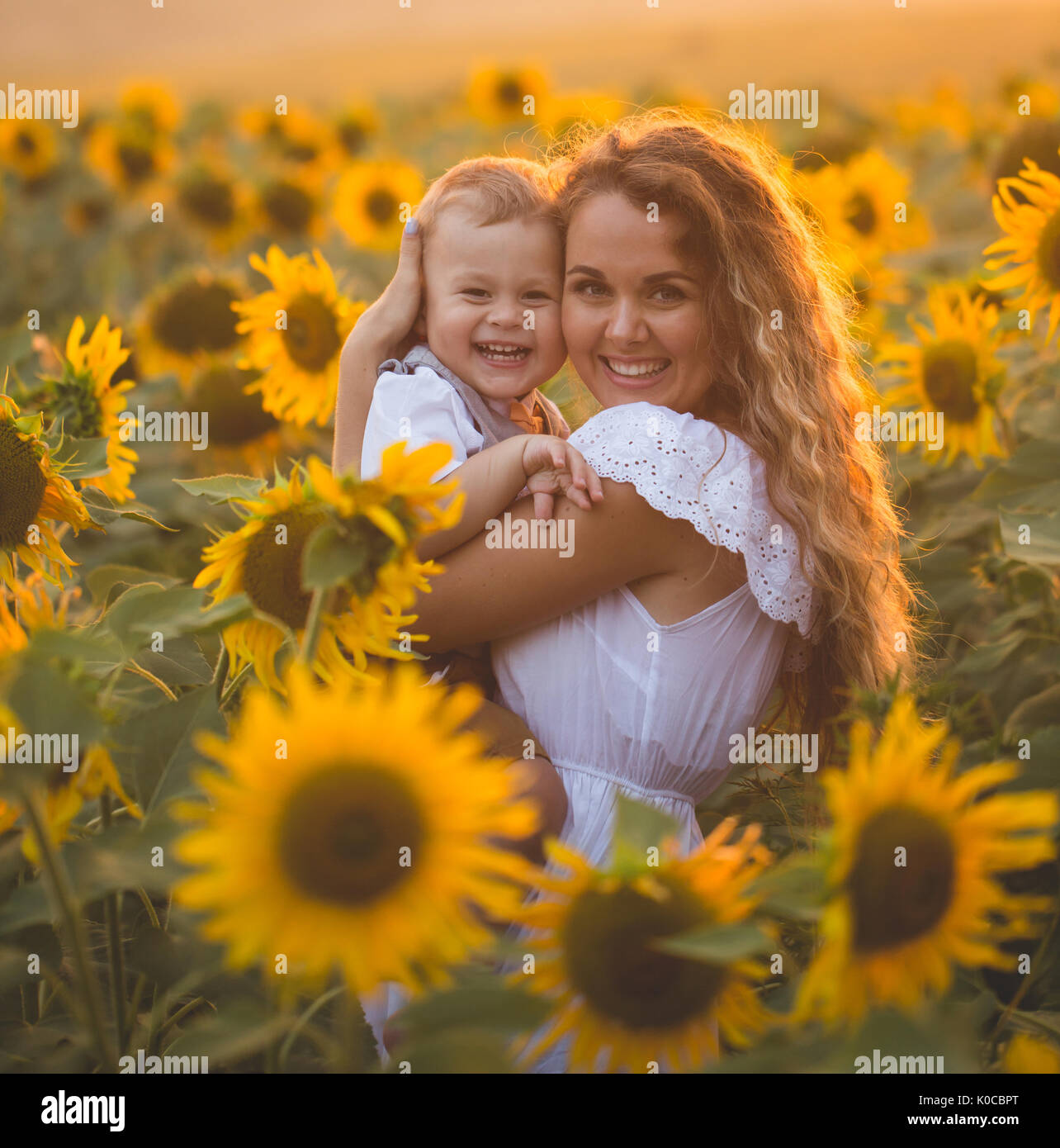 Mother with baby son in sunflower field Stock Photo - Alamy