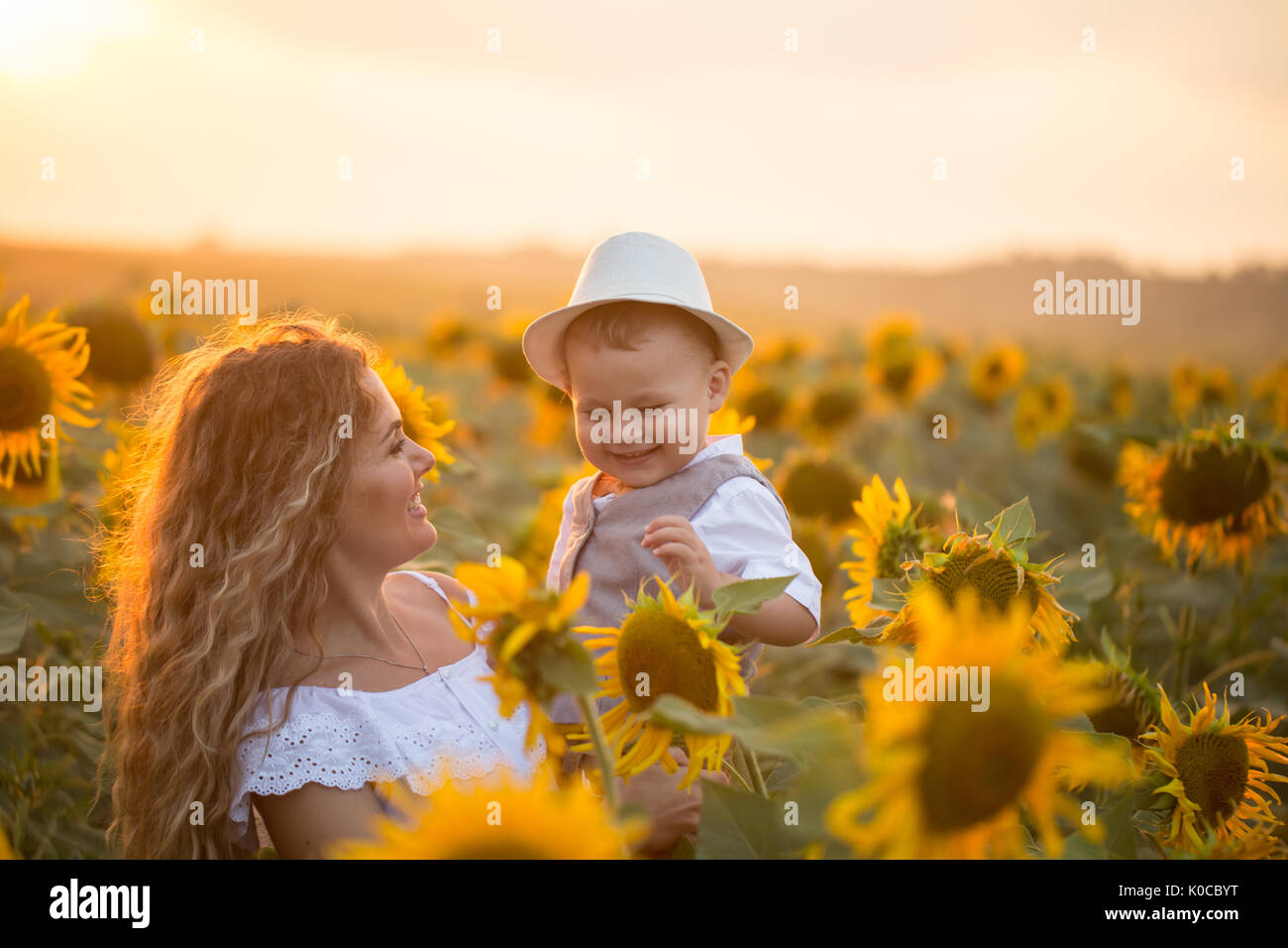 Mother with baby son in sunflower field Stock Photo - Alamy