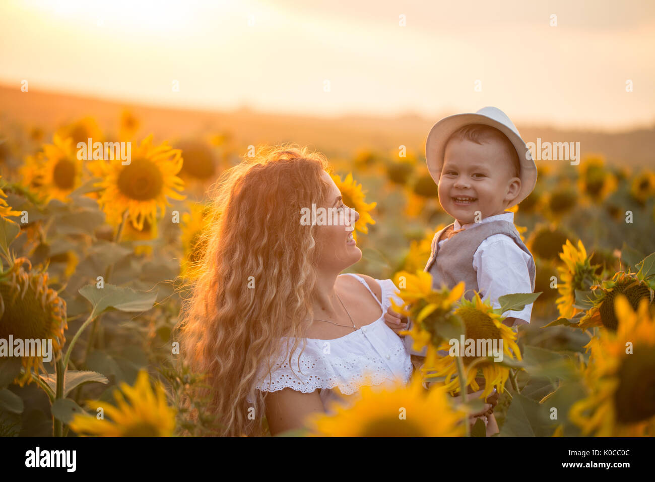 Mother with baby son in sunflower field Stock Photo - Alamy