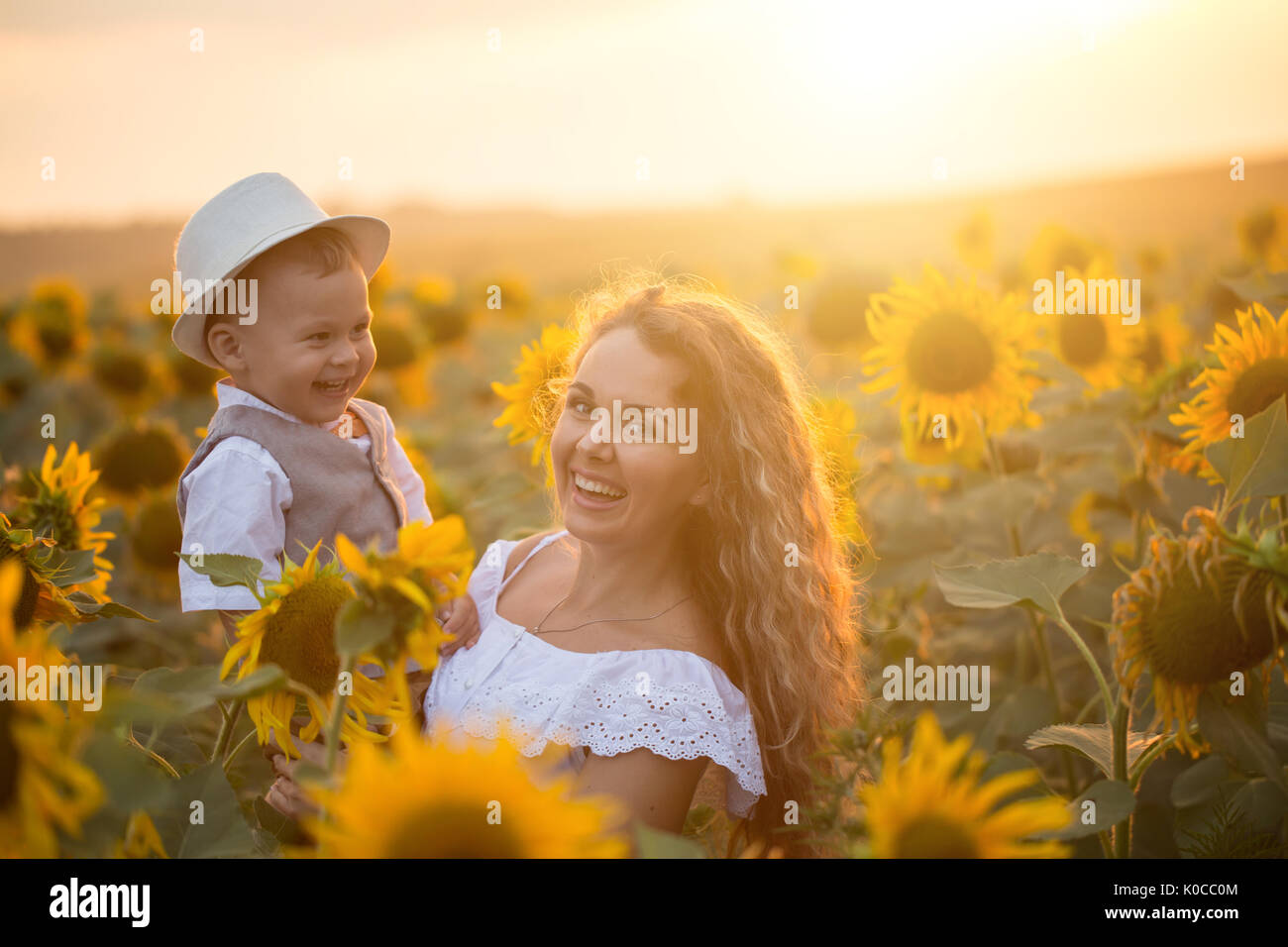 Mother with baby son in sunflower field Stock Photo - Alamy