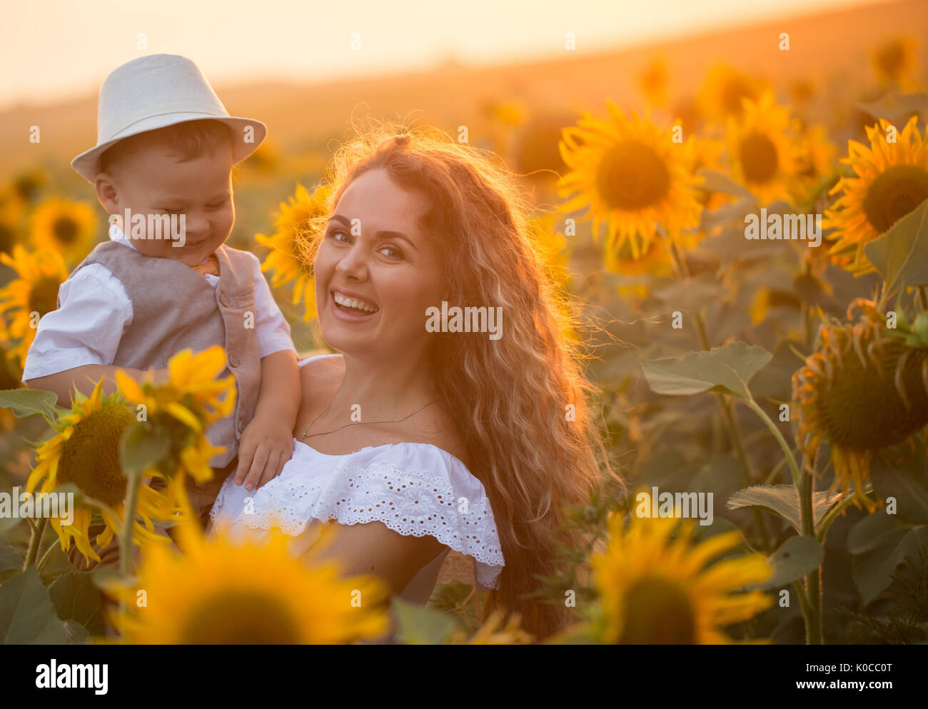 Mother with baby son in sunflower field Stock Photo - Alamy