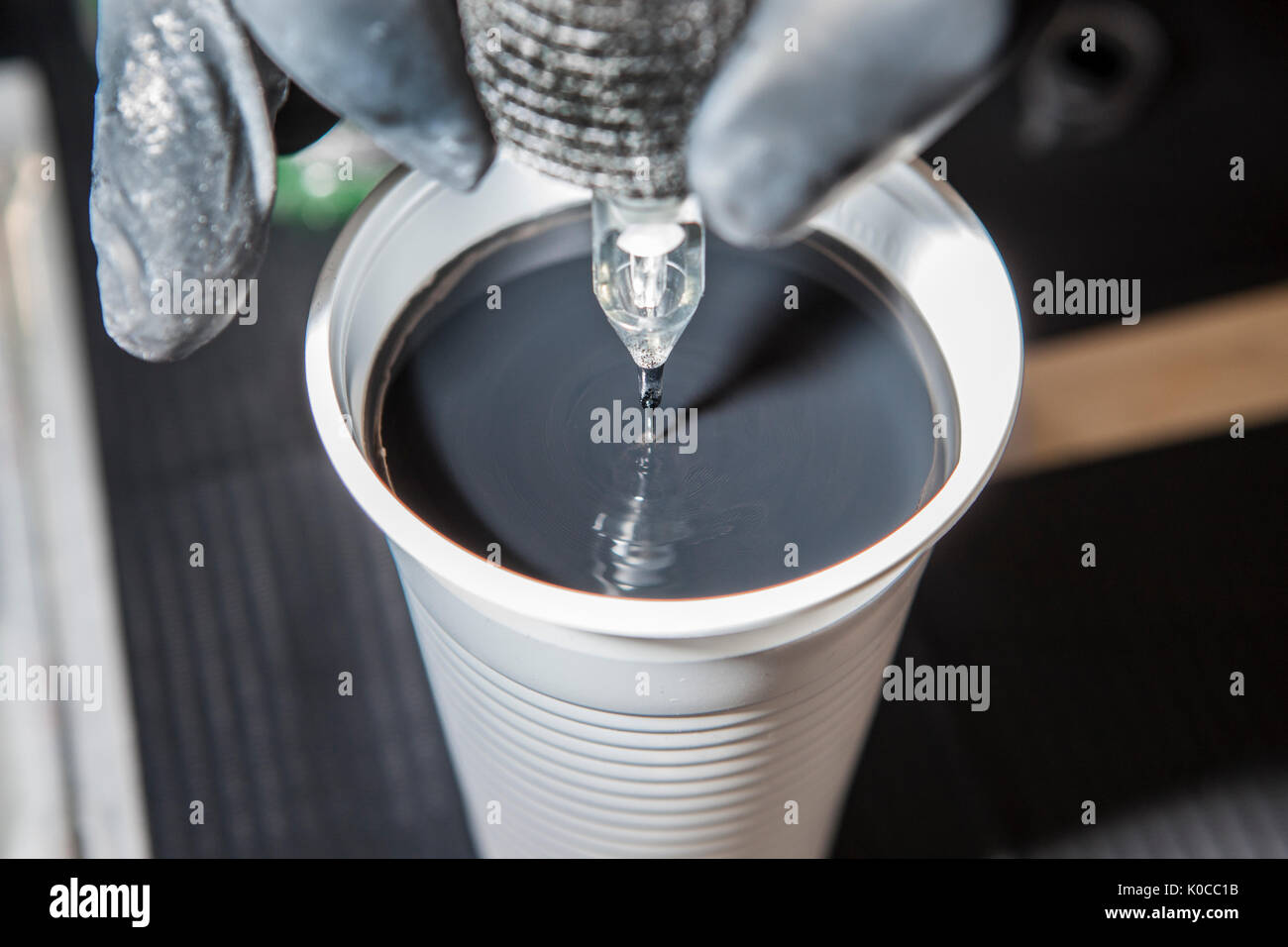 Tattoo artist cleaning the machine needles on water. Closeup Stock
