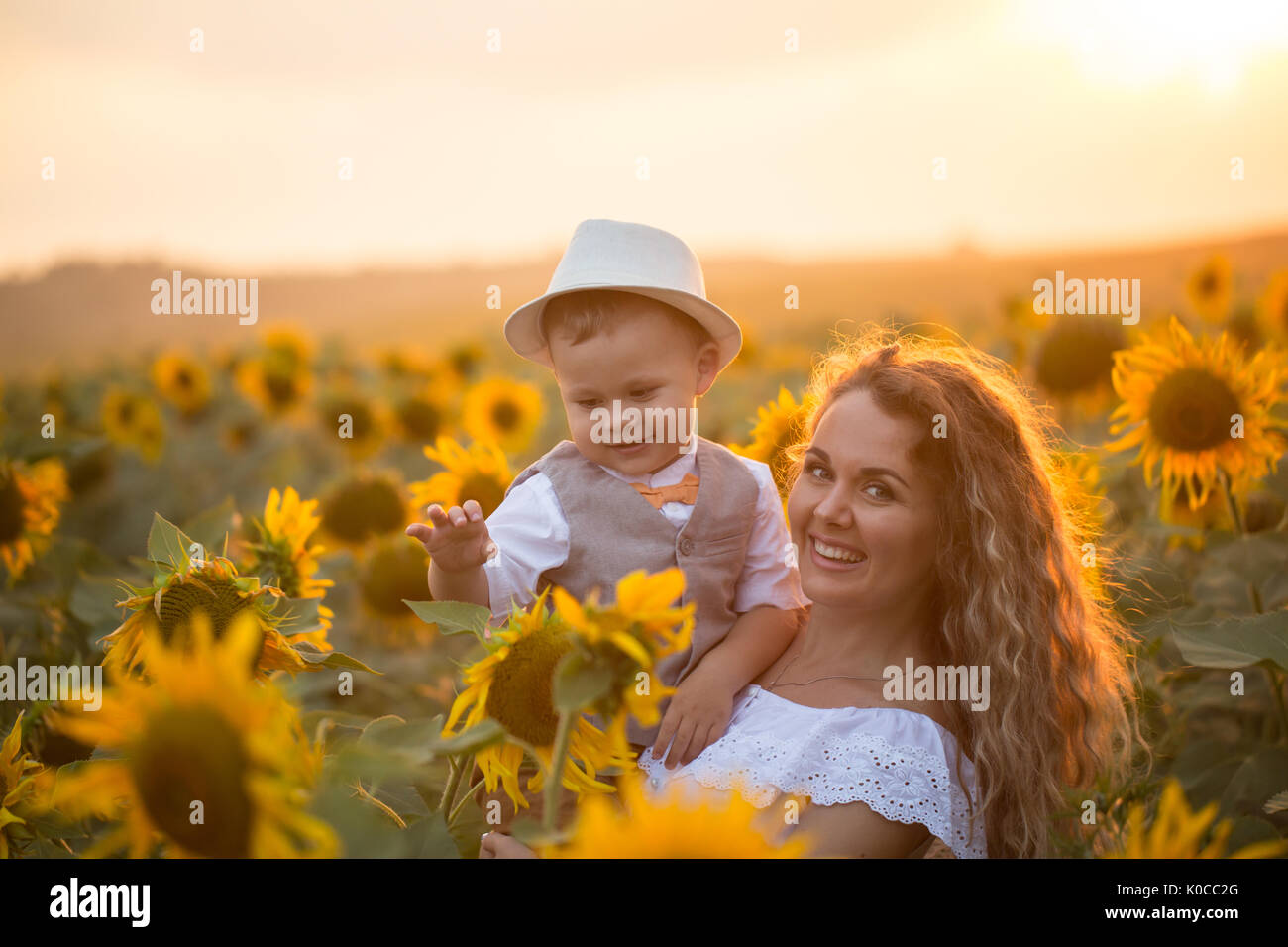 Mother with baby son in sunflower field Stock Photo - Alamy