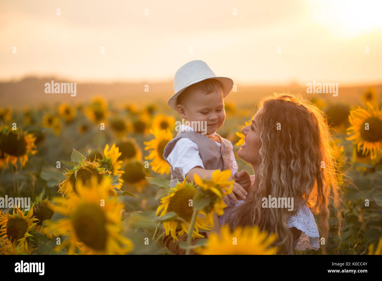 Mother with baby son in sunflower field Stock Photo - Alamy